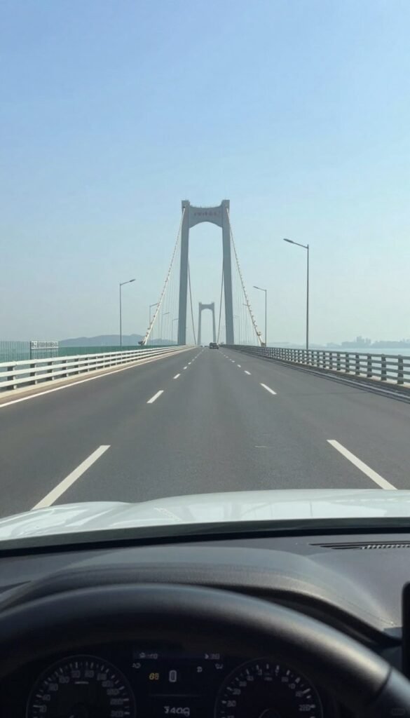 View from car driving across long bridge over water representing bridge driving fear View from car driving across long bridge over water representing bridge driving fear